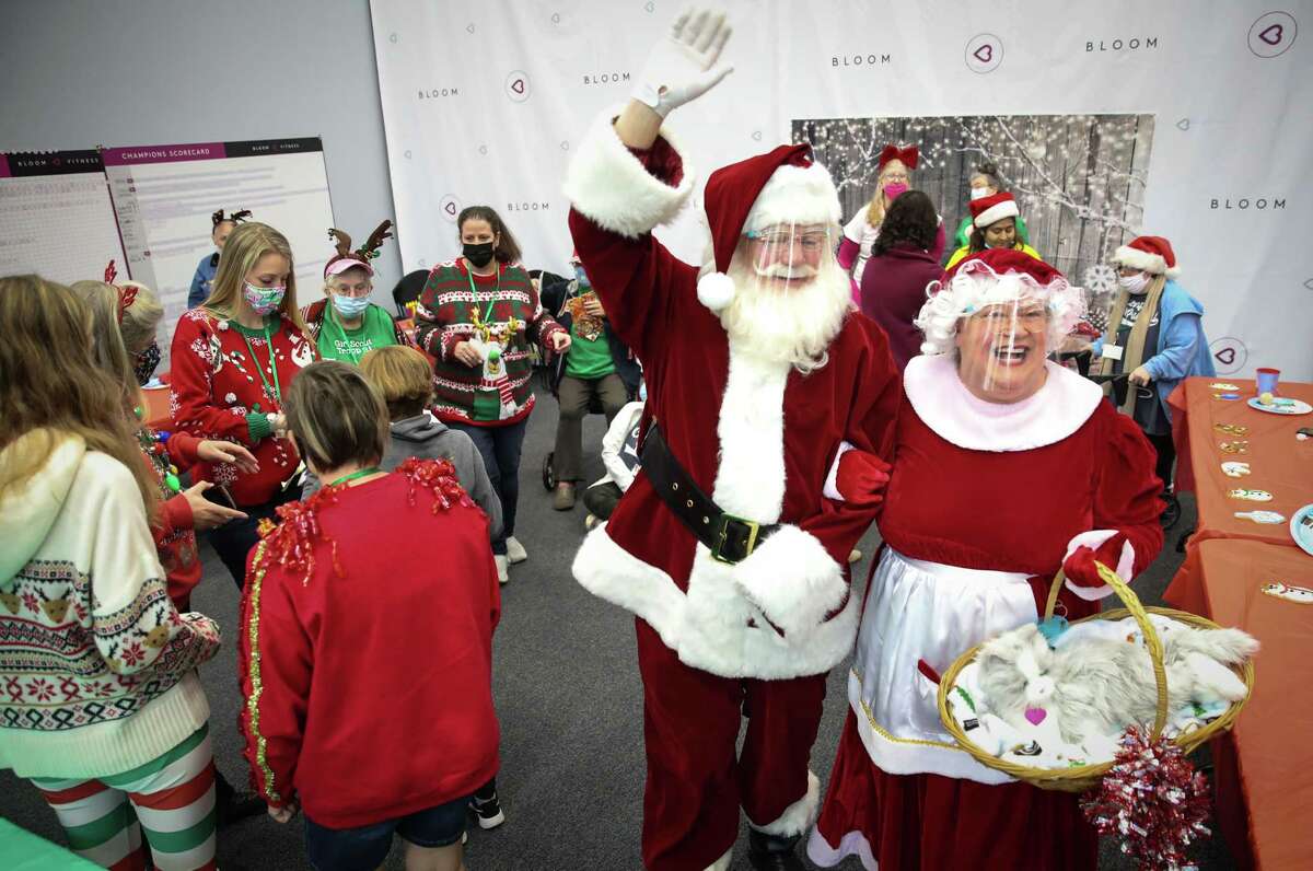Santa Claus and Mrs. Claus, played by James McDaniel and Tina Sabuco, perform during a holiday celebration for Girl Scout Troop 21 on Saturday, Dec. 11, 2021, at The Center for Pursuit in Houston. The troop is made of adult women with varying communication and learning abilities.
