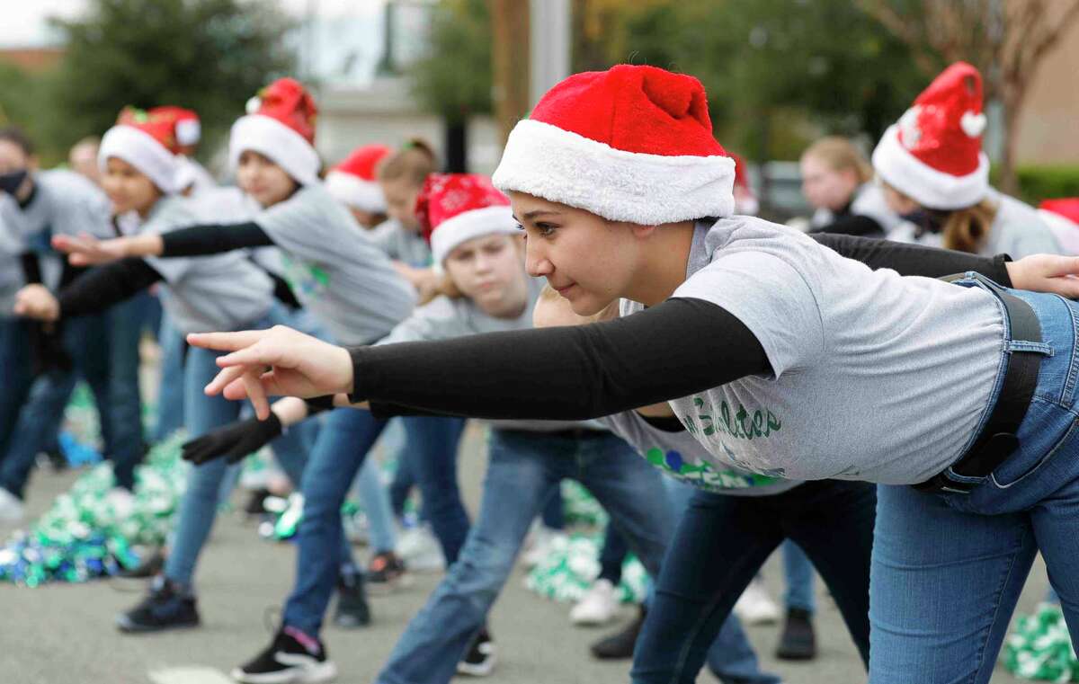 Members of the Green Starelettes drill team stretch before the annual Conroe Christmas parade, Saturday, Dec. 11, 2021, in Conroe.