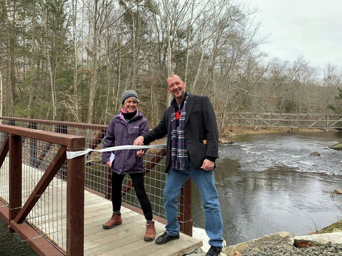 Roxbury Land Trust Board President Julie Steers and Roxbury First Selectman Patrick Roy cut the ribbon to officially open the new Volunteers Bridge across the Shepaug River.