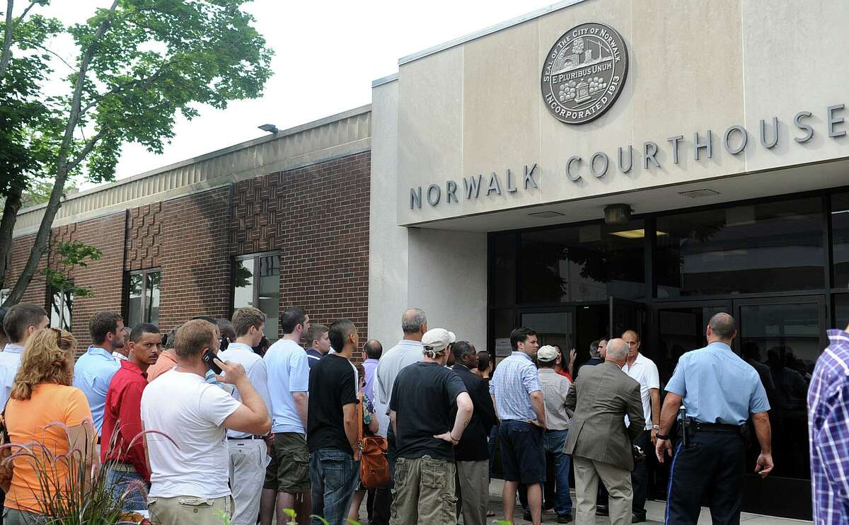 A long line forms outside the Norwalk Court house on Belden Street in Norwalk, Conn. after a power outage left the building without lights, air conditioning, computers or metal detectors on Friday, June 22, 2012.