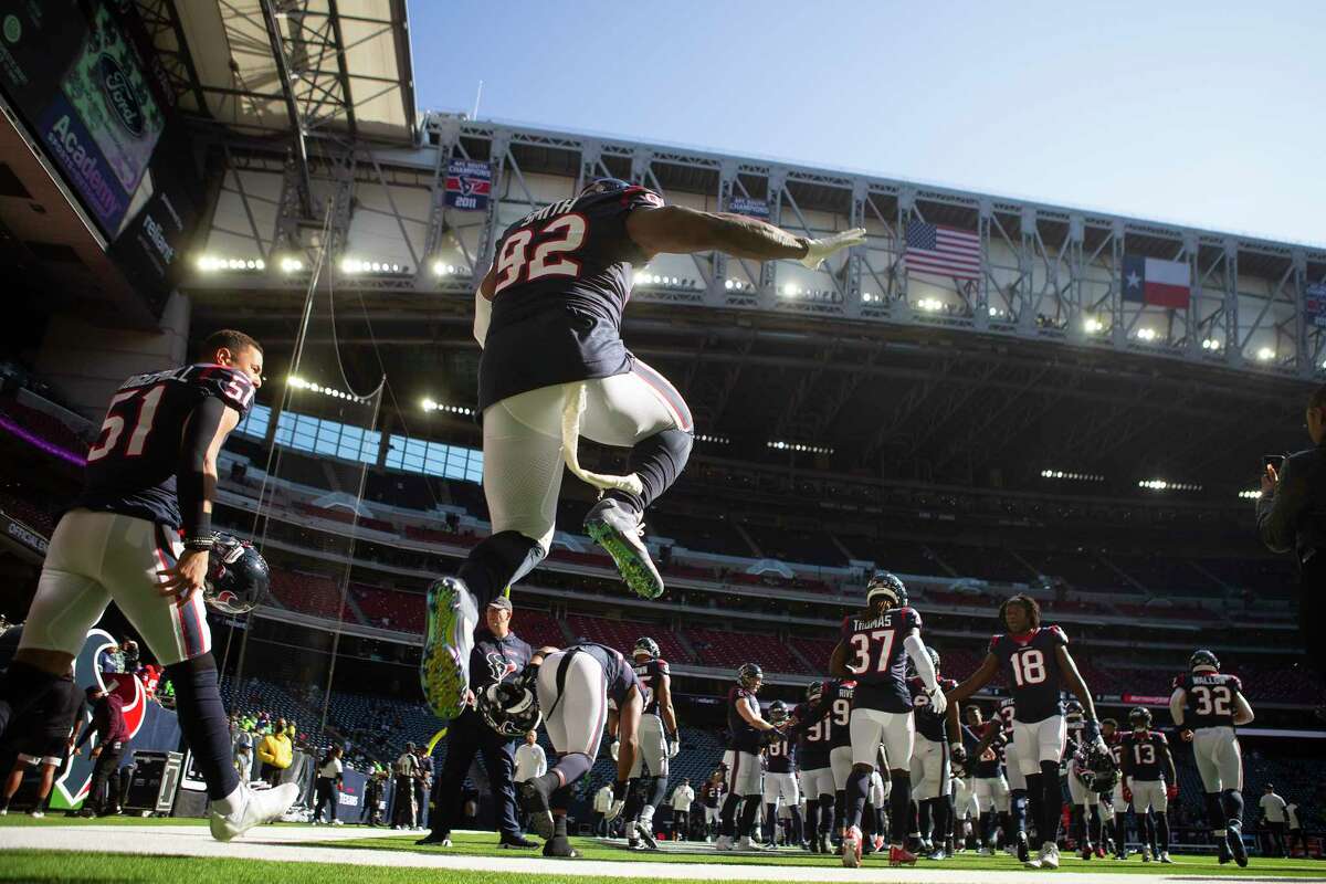 Houston Texans players run onto he field under an open roof before an NFL football game against the Seattle Seahawks Sunday, Dec. 12, 2021 in Houston.