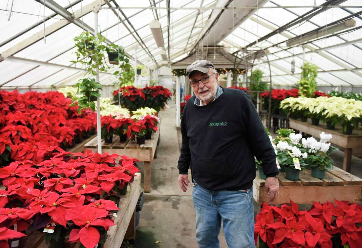 Business owner Michael "Mickey" Doyle shows the holiday flower collection at Springdale Florist & Greenhouses in Darien, Conn. Monday, Dec. 6, 2021. Springdale Florist will celebrate its 100 year anniversary in January of 2022.