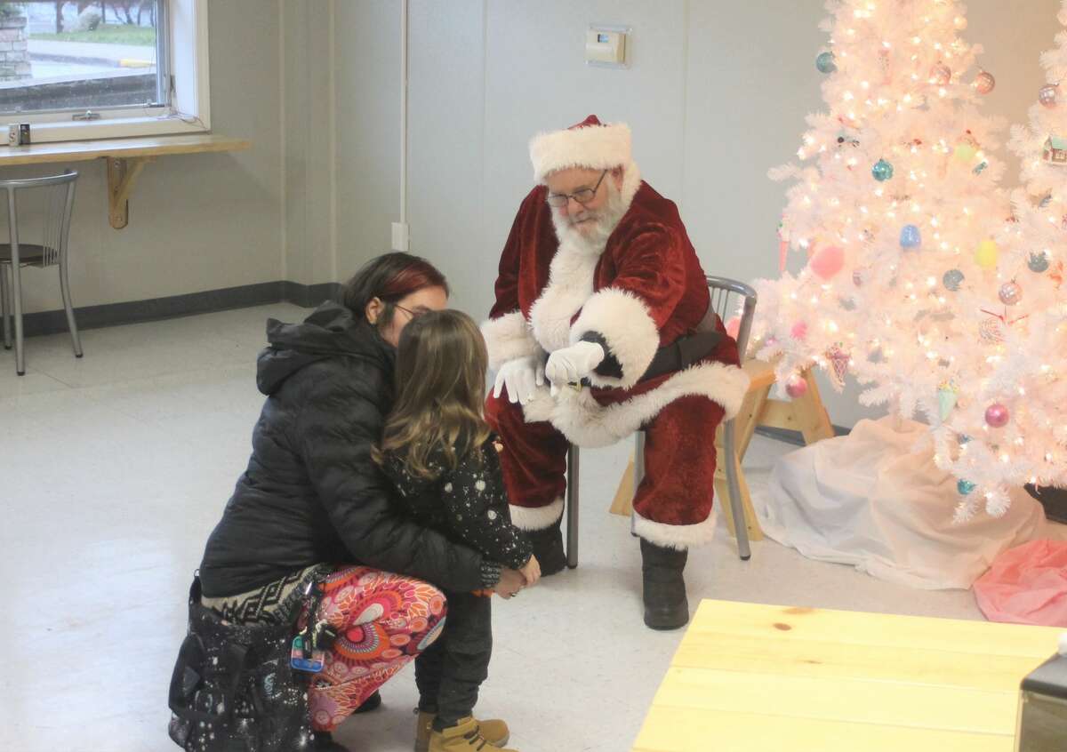 Santa Claus attempts to get on Jaxn Chandler's good side by offering up a fist bump in Downtown Delights on Saturday.
