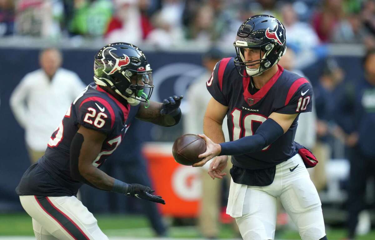 Houston Texans quarterback Davis Mills (10) hands the ball off to running back Royce Freeman (26) during the first half of an NFL football game at NRG Stadium, Sunday, Dec. 12, 2021 in Houston .