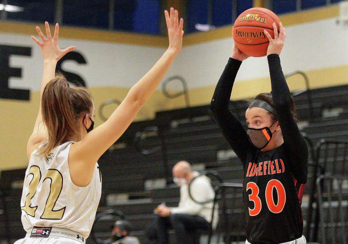 Ridgefied's Kaya Weiskopf (3) looks to pass the ball as Trumbull's Julia Lindwall tries to block during girls basketball action in Trumbull, Conn., on Wednesday Feb.10, 2021.