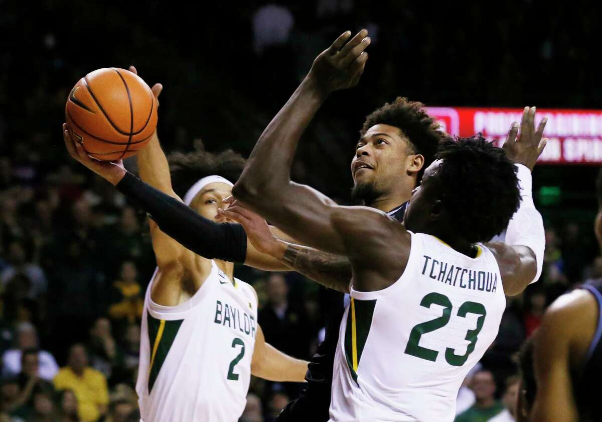 Villanova guard Justin Moore, left, drives past Baylor forward Jonathan Tchamwa Tchatchoua (23) to the basket during the first half of an NCAA college basketball game on Sunday, Dec. 12, 2021, in Waco, Texas.