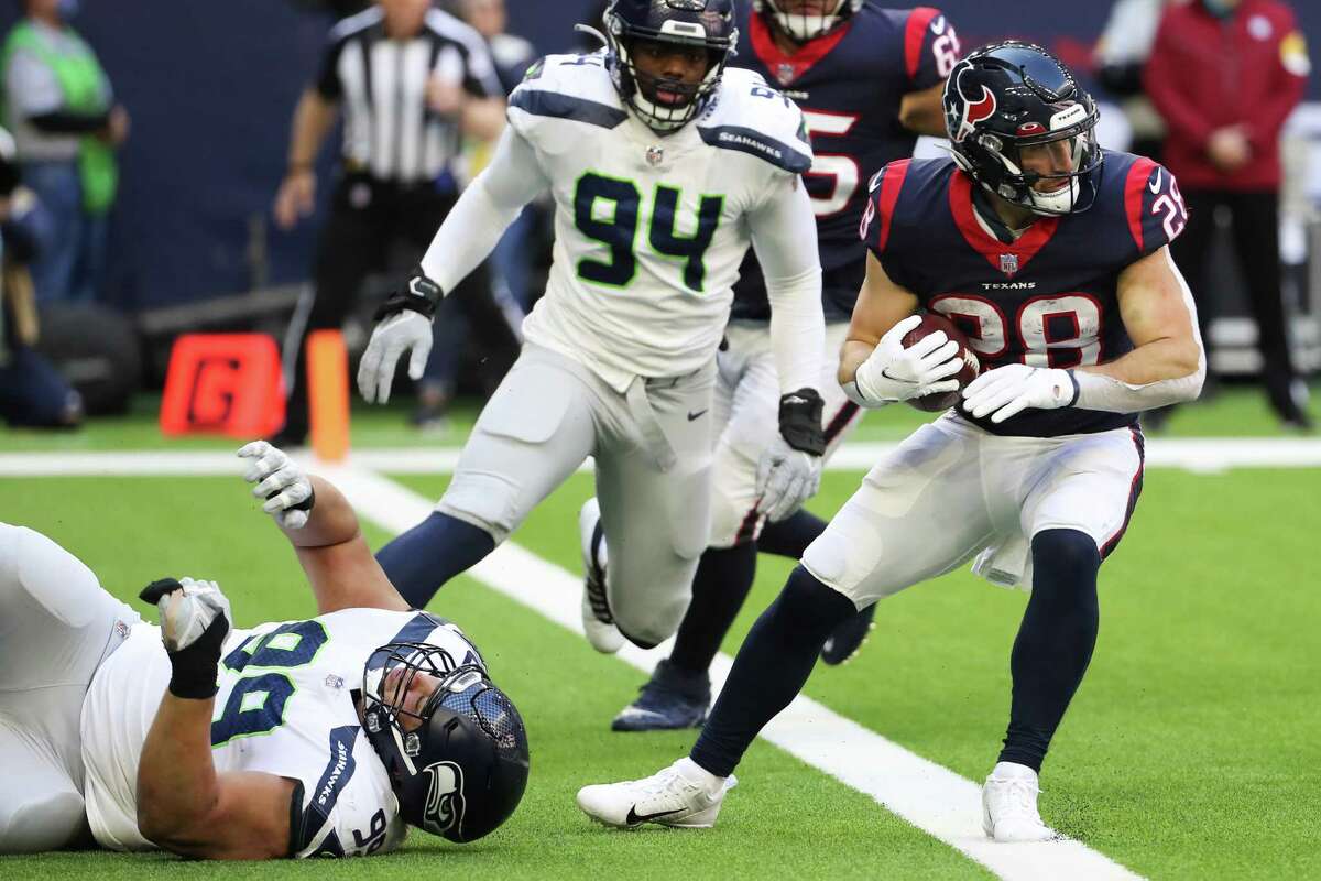 Seattle Seahawks defensive tackle Al Woods (99) falls to the turf after hitting Houston Texans running back Rex Burkhead (28) as Burkhead tries to run out of the end zone during the second quarter of an NFL football game Sunday, Dec. 12, 2021 in Houston.