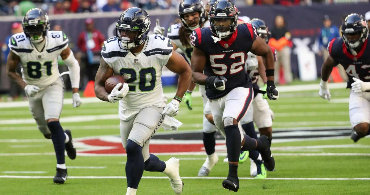 Seattle Seahawks running back Rashaad Penny (20) runs past Houston Texans defensive end Jonathan Greenard (52) on his way to a 47-yard touchdown run during the fourth quarter of an NFL football game Sunday, Dec. 12, 2021 in Houston.