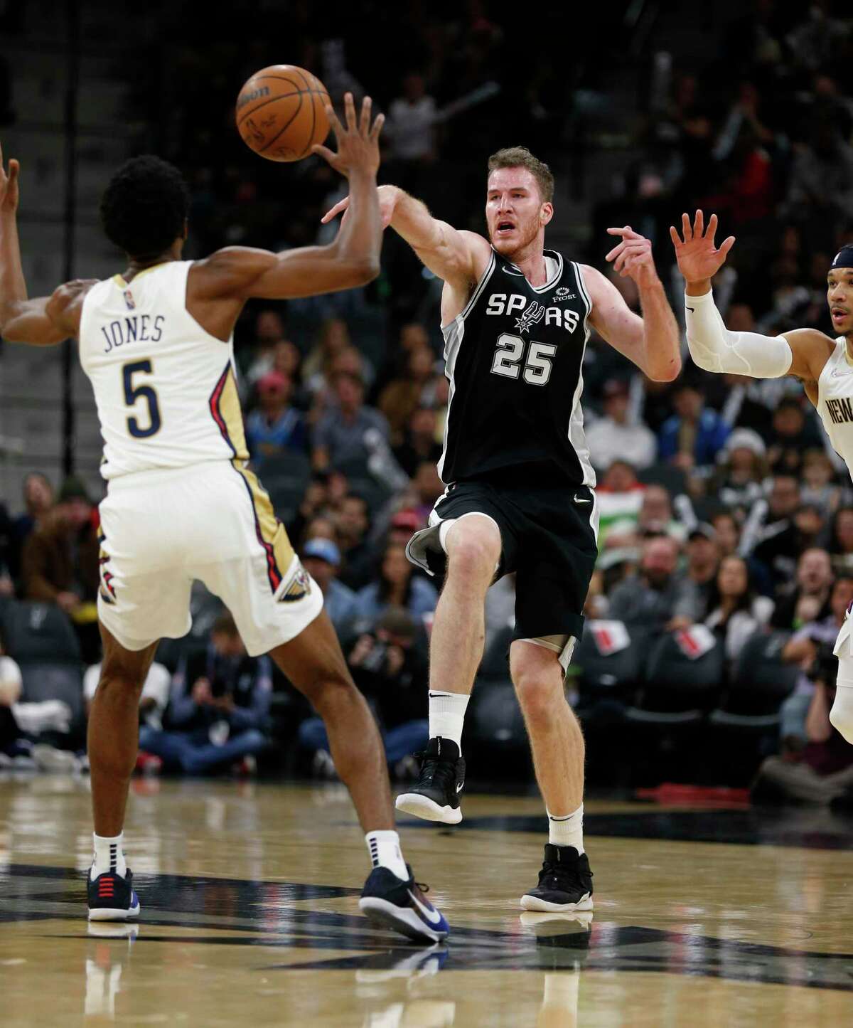 SAN ANTONIO, TX - DECEMBER 12: Jakob Poeltl #25 of the San Antonio Spurs has his pass intercepted by Josh Gray #5 of the New Orleans Pelicans in the second half at AT&T Center on December 12, 2021 in San Antonio, Texas. NOTE TO USER: User expressly acknowledges and agrees that , by downloading and or using this photograph, User is consenting to the terms and conditions of the Getty Images License Agreement. (Photo by Ronald Cortes/Getty Images)