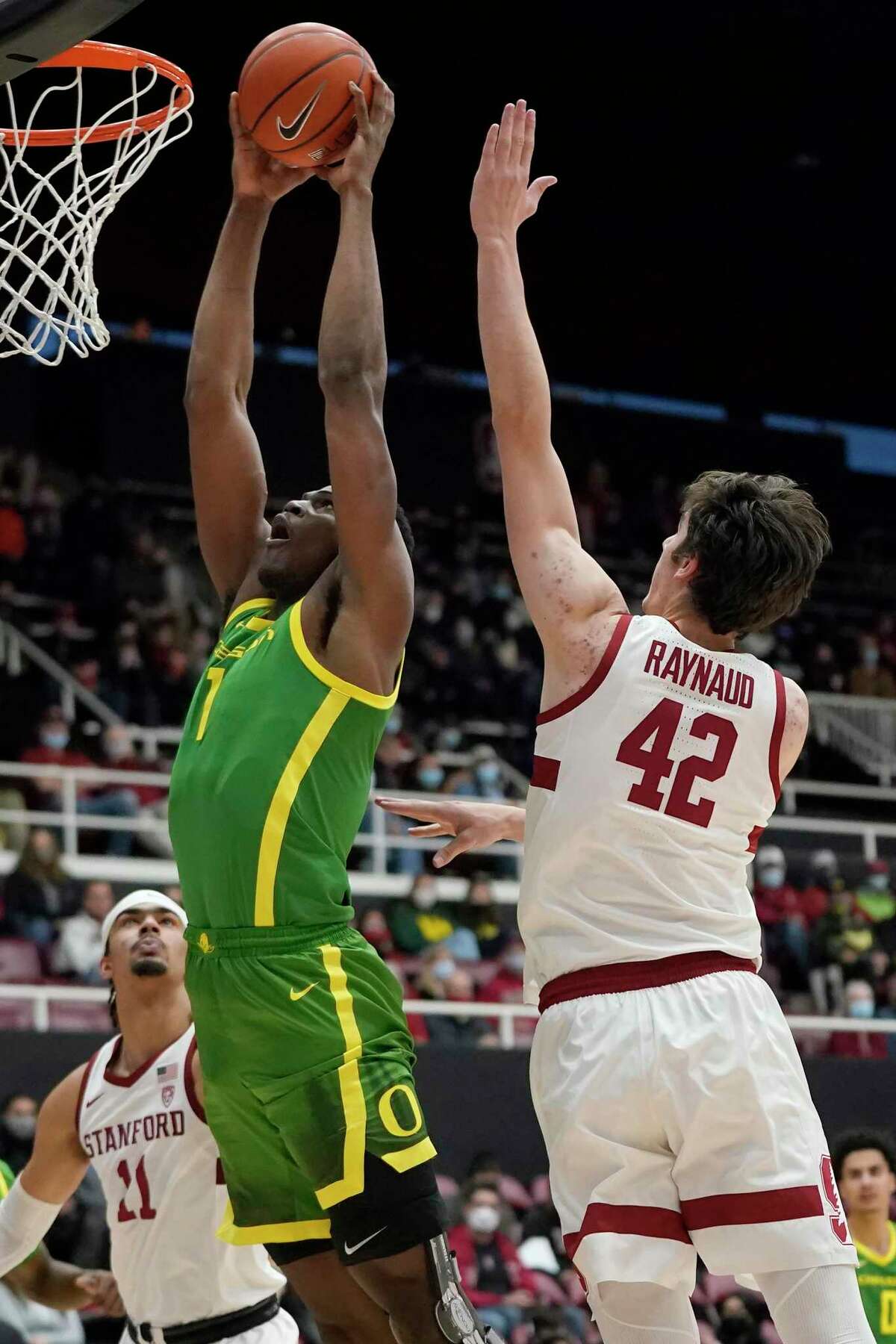 Oregon center N'Faly Dante, left, dunks next to Stanford forward Maxime Raynaud (42) during the first half of an NCAA college basketball game in Stanford, Calif., Sunday, Dec. 12, 2021. (AP Photo/Jeff Chiu)