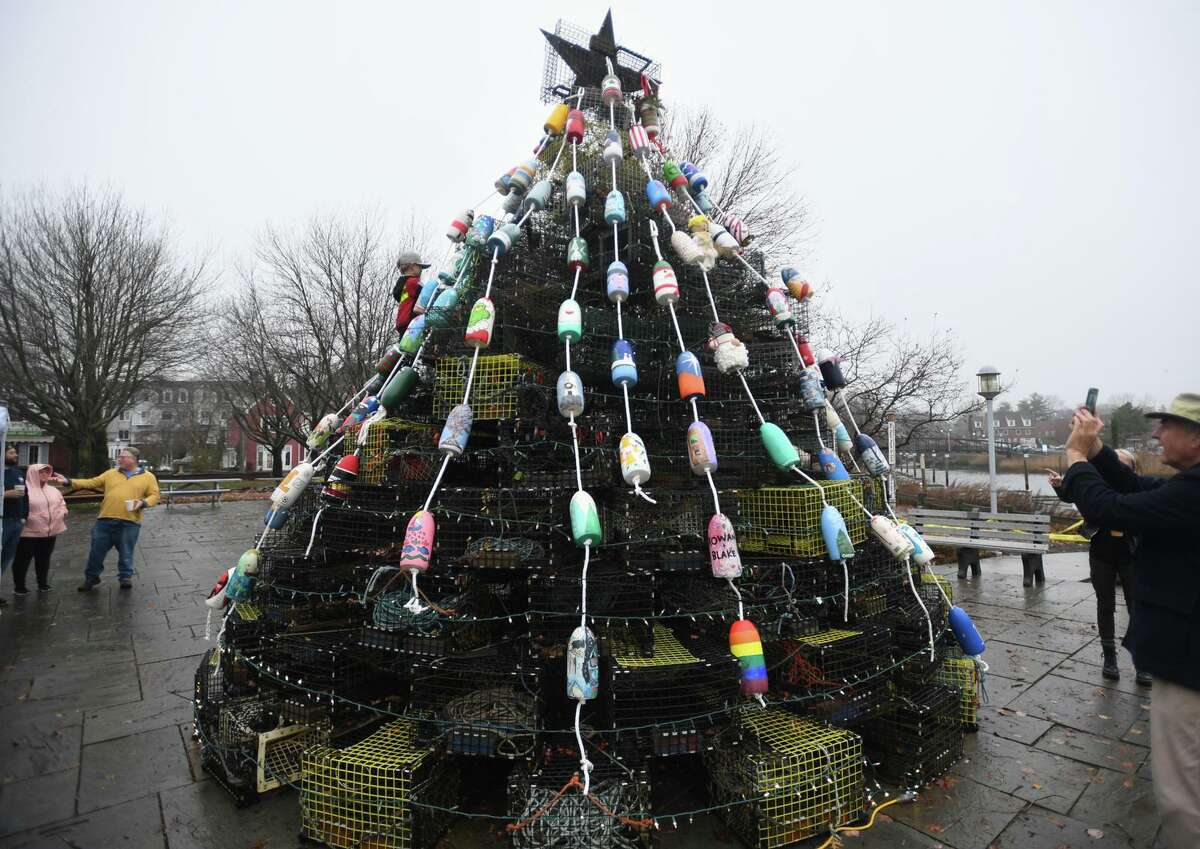 Milford's first ever lobster trap tree decorated with painted buoys raising money for the Milford Arts Council is installed at Lisman Landing in Milford on Saturday, Dec. 11.