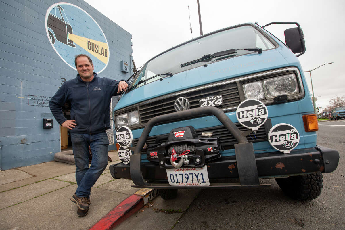 Owner Marco Greywe poses with one of his customized Vanagons outside Buslab, an auto mechanic shop that specializes in repairing Volkswagen vans, in Berkeley, Calif. on Dec. 8, 2021.