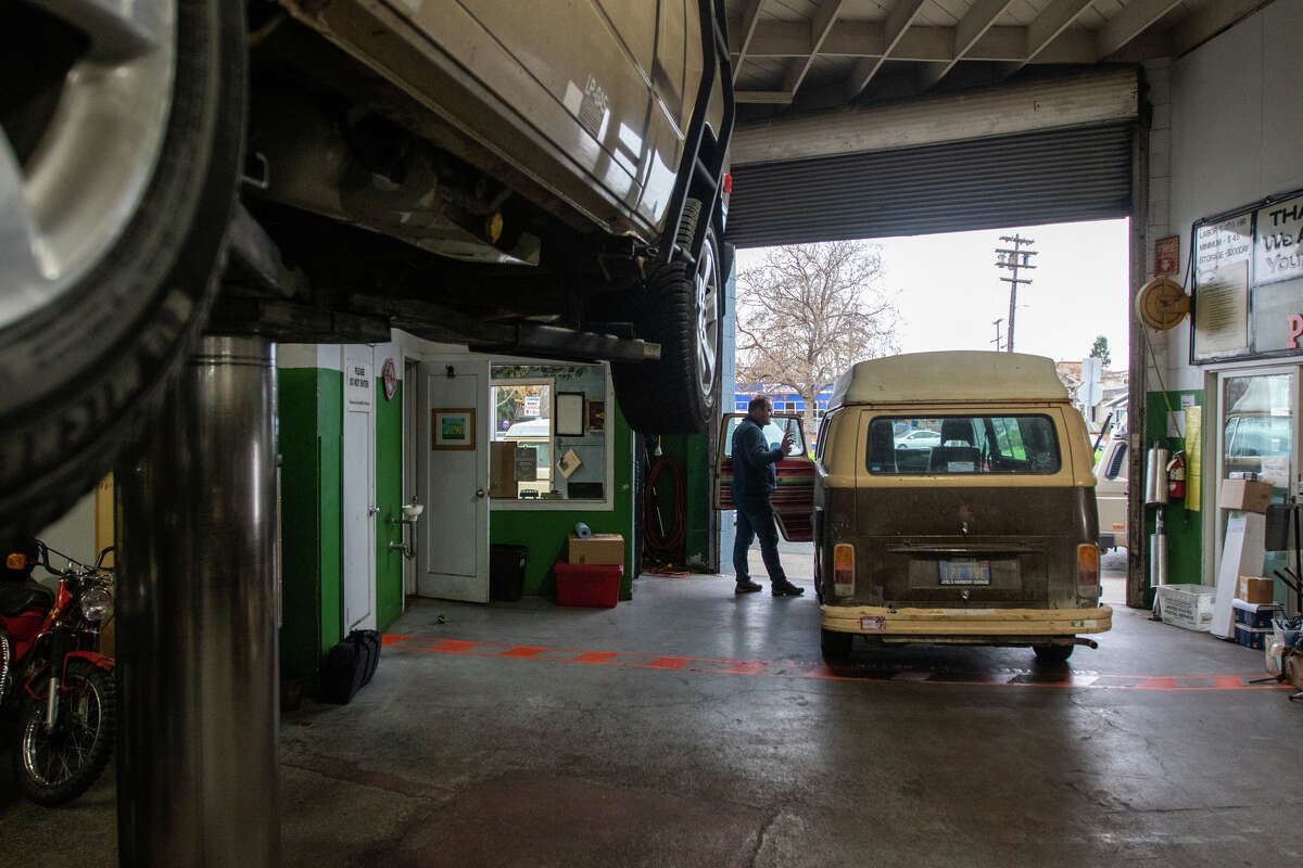 Owner Marco Greywe talks with a mechanic driving a van at Buslab. 