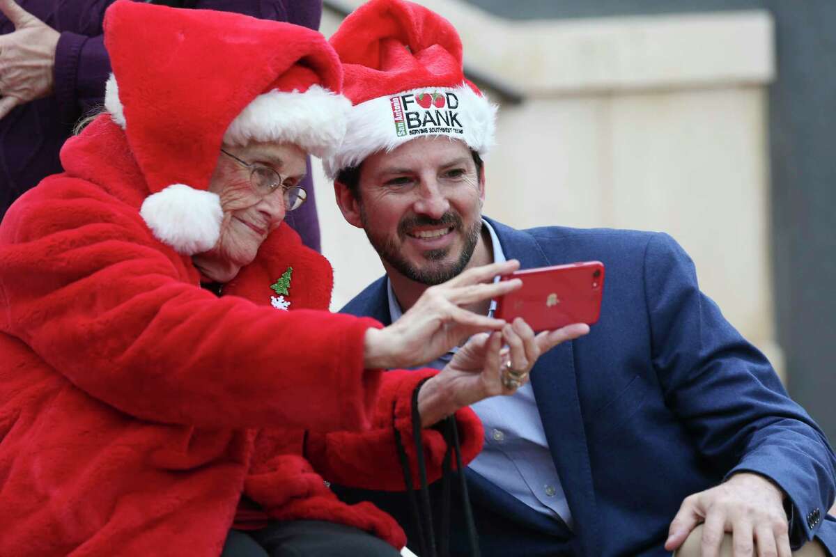 Betty Eckert, 91, a member of the City-County Joint Commission on Elderly Affairs, takes a photo with San Antonio District 1 City Councilman Mario Bravo before the “Convoy of Hope” news conference in front of City Hall on Monday, Dec. 13, 2021.