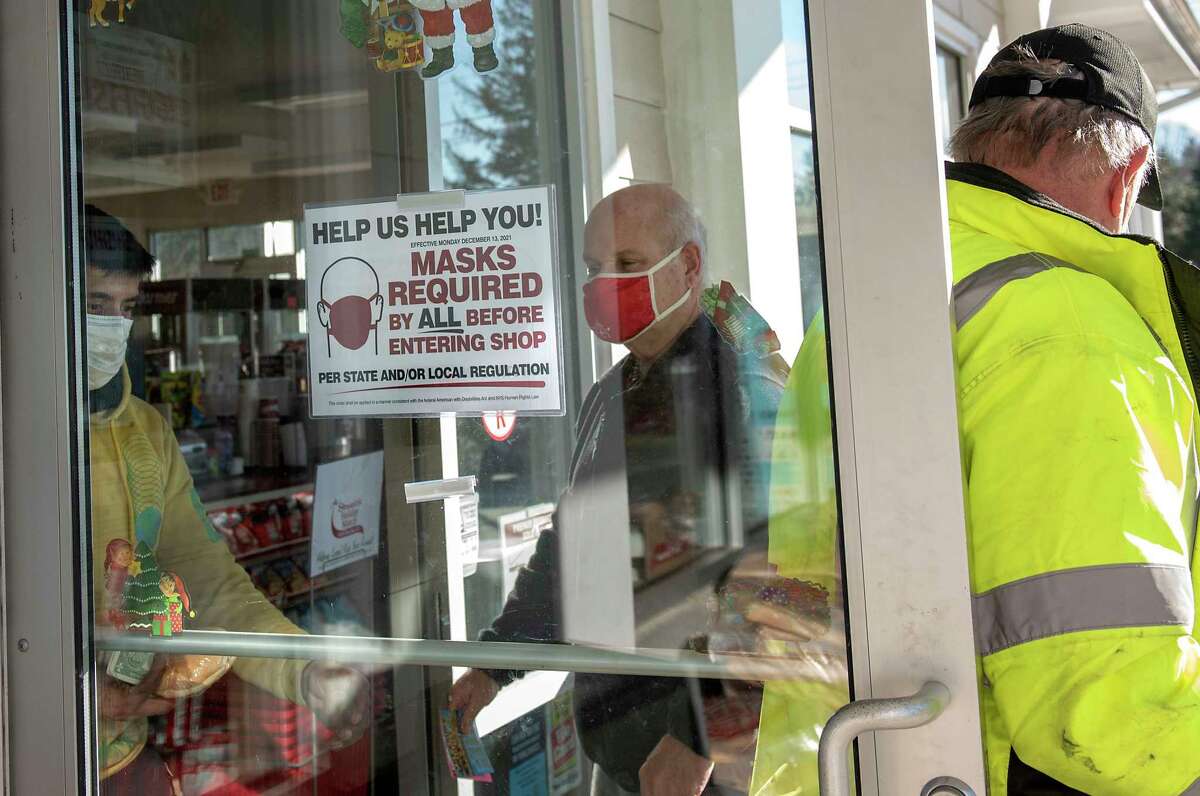 Customers are seen leaving and entering a Stewart’s Shops store on Monday, Dec. 13, 2021 in Clifton Park, N.Y A sign is posted on the door of the new state mask mandate.