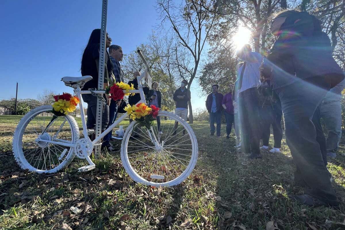 Family members of Joel Middaugh, a Houston father and art model, watch as Steve and Melissa Sims install a ghost bike is installed in the 2800 block of West Little York Road, near the site where Middaugh died, on Dec. 12, 2021. 