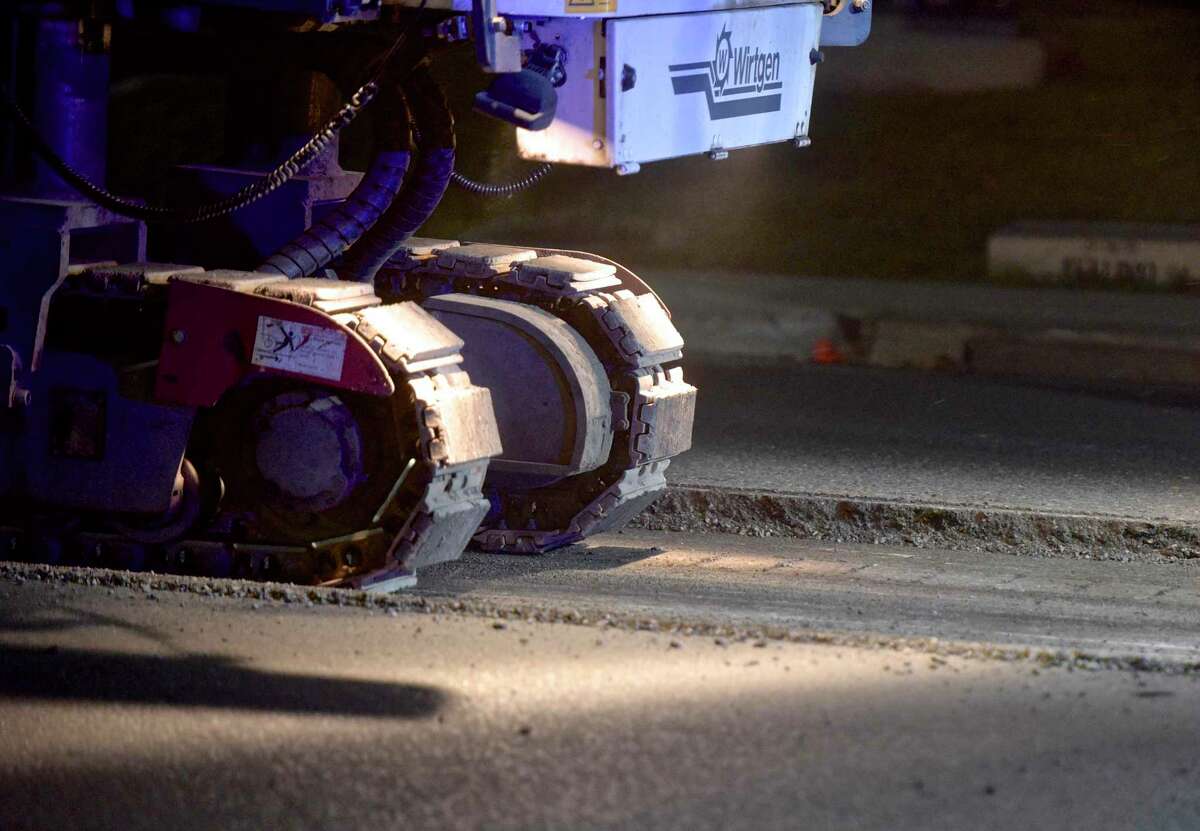 In this file photo, a milling machine removes part of the road as crews began milling the road surface near the intersection of North Street and Padanaram Road on Wednesday, May 30, 2018, in Danbury, Conn. The city paved 21.4 miles of roadway this construction season. This includes milling or reclaiming 7.42 miles of road.