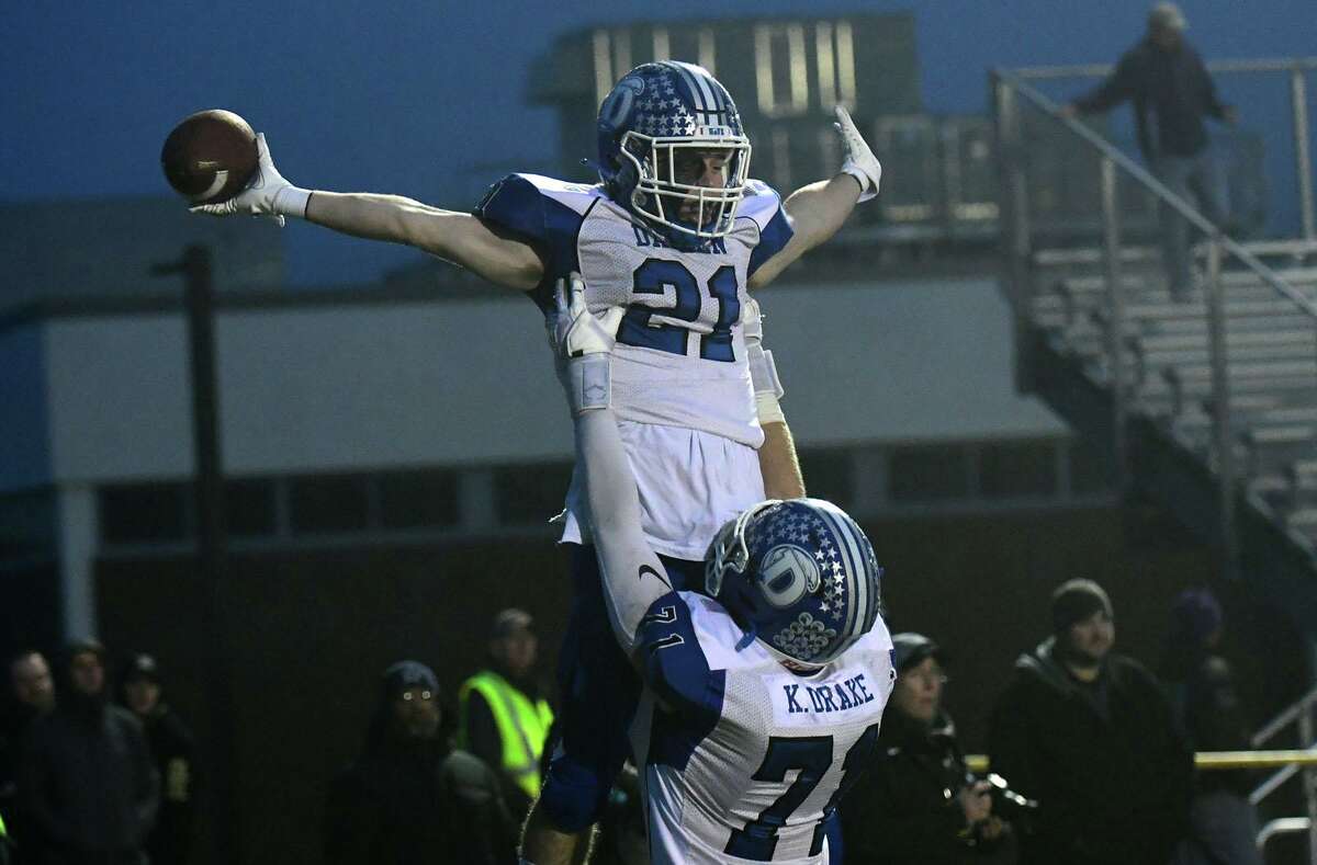 Blue Wave #71 Carter Hagen lifts #21 Jeremiah Stafford after a score during the Class LL state championship football game between No. 1 Fairfield Prep Jesuits and No. 3 Darien High School Blue Wave Saturday, December 11, 2021, at Trumbulll High School in Trumbull, Conn.