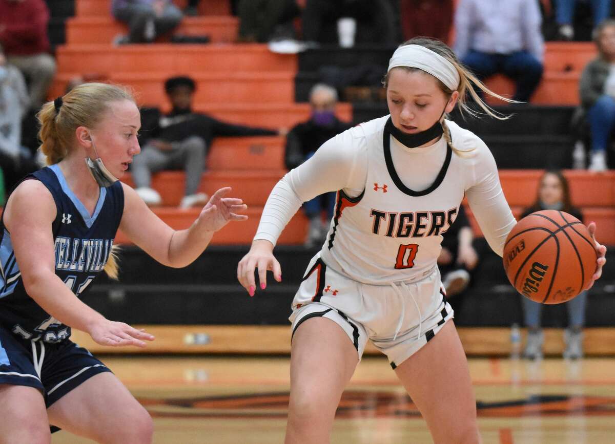 Edwardsville's Kate Conner shields the ball away from a Belleville East defender during a game inside Lucco-Jackson Gymnasium.