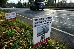 Opposition signs across the street from a vacant lot at 283 Richards Ave. Tuesday, December 7, 2021, in Norwalk, Conn. The lot is where a local Sikh organization is looking to build a religious center in the residential neighborhood.