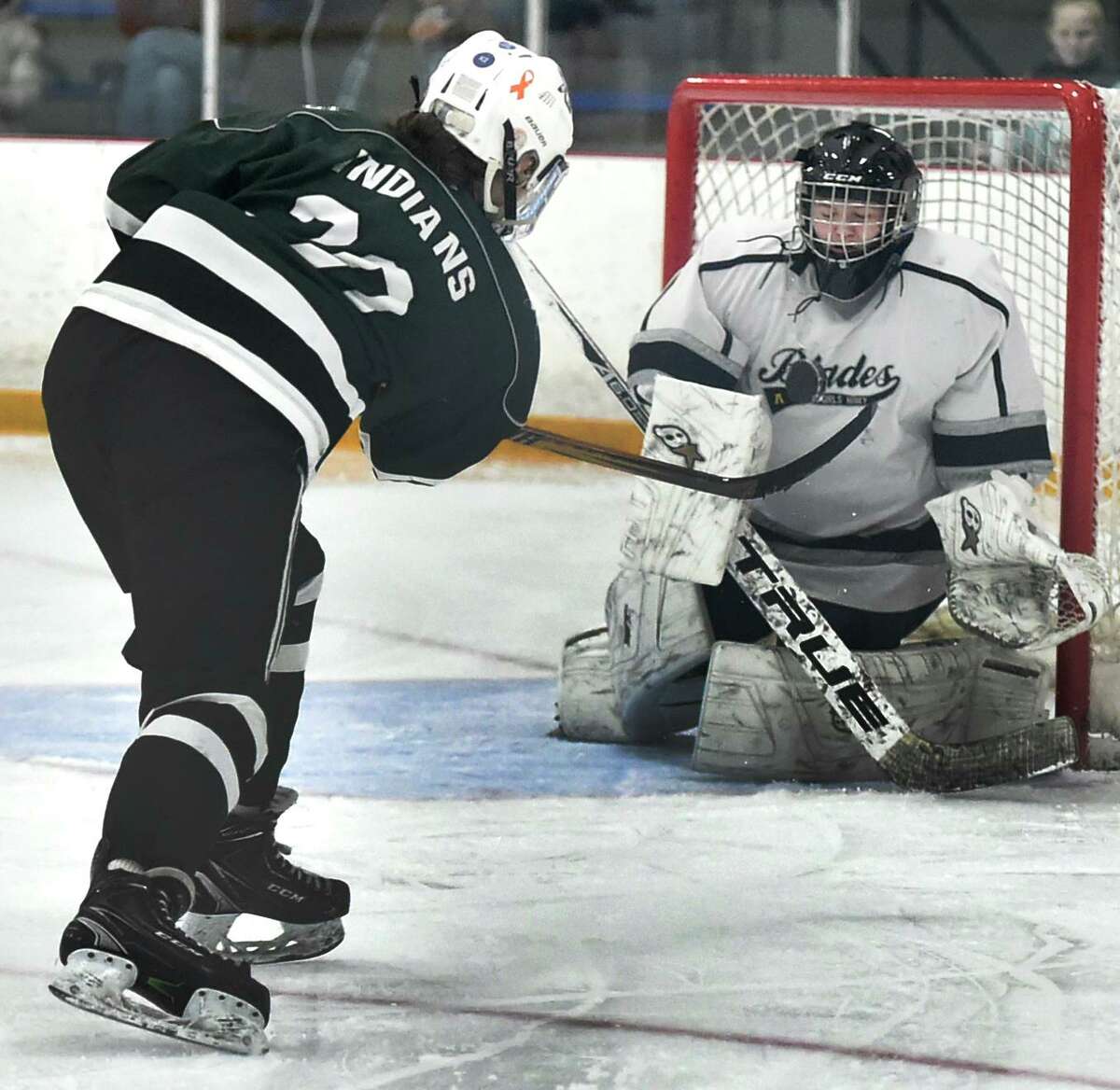 West Haven, Connecticut - February 29, 2020: Maddie Epke of Guilford takes a shot on goal, left, against goalie Jude Krukar of Amity/New Haven/ Cheshire Blades, right, goal during the second period of the SCC 2020 Girls Ice Hockey Championship Saturday afternoon at Bennett Rink in West Haven.