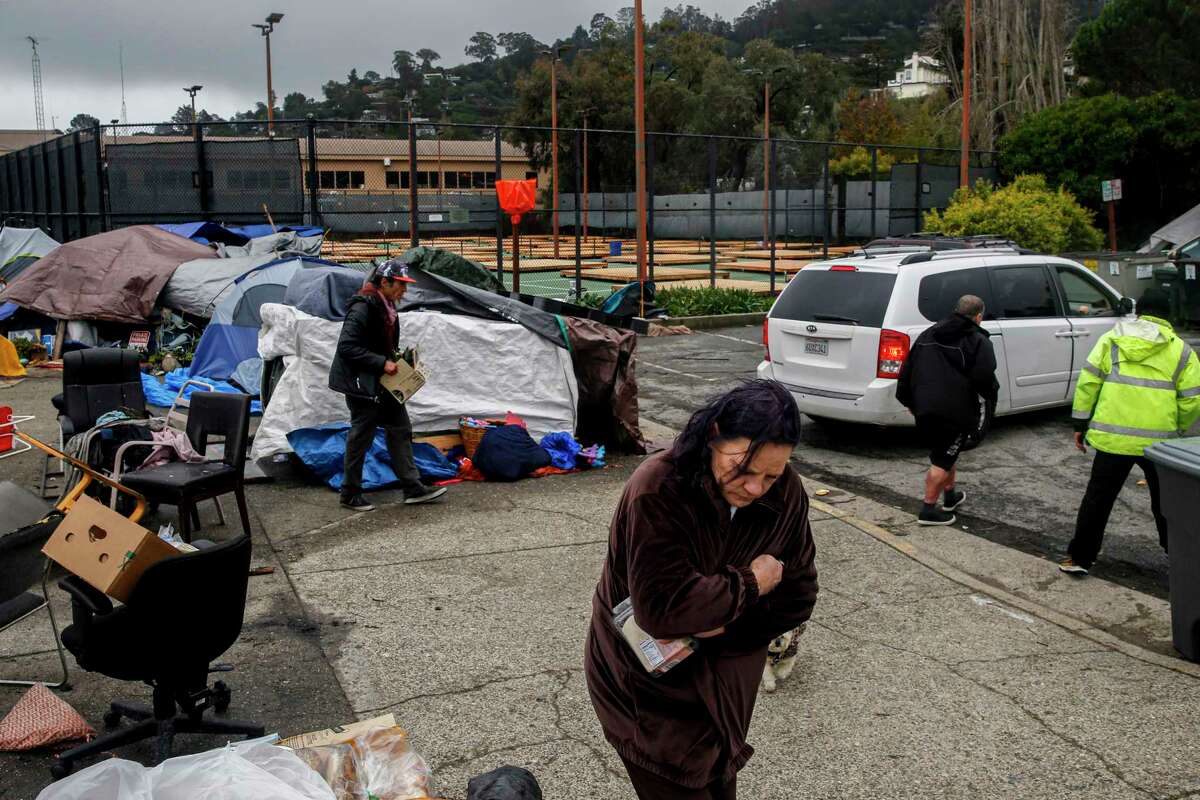 Wooden platforms can be seen behind a locked gate at a tennis court near a homeless encampment at Marinship in Sausalito, Calif. on Monday, Dec. 13, 2021. The platforms, a city project contracting with Urban Alchemy, will provide elevation for unhoused residents living in the field nearby. But a date for when the residents can move to the platforms has yet to be announced.