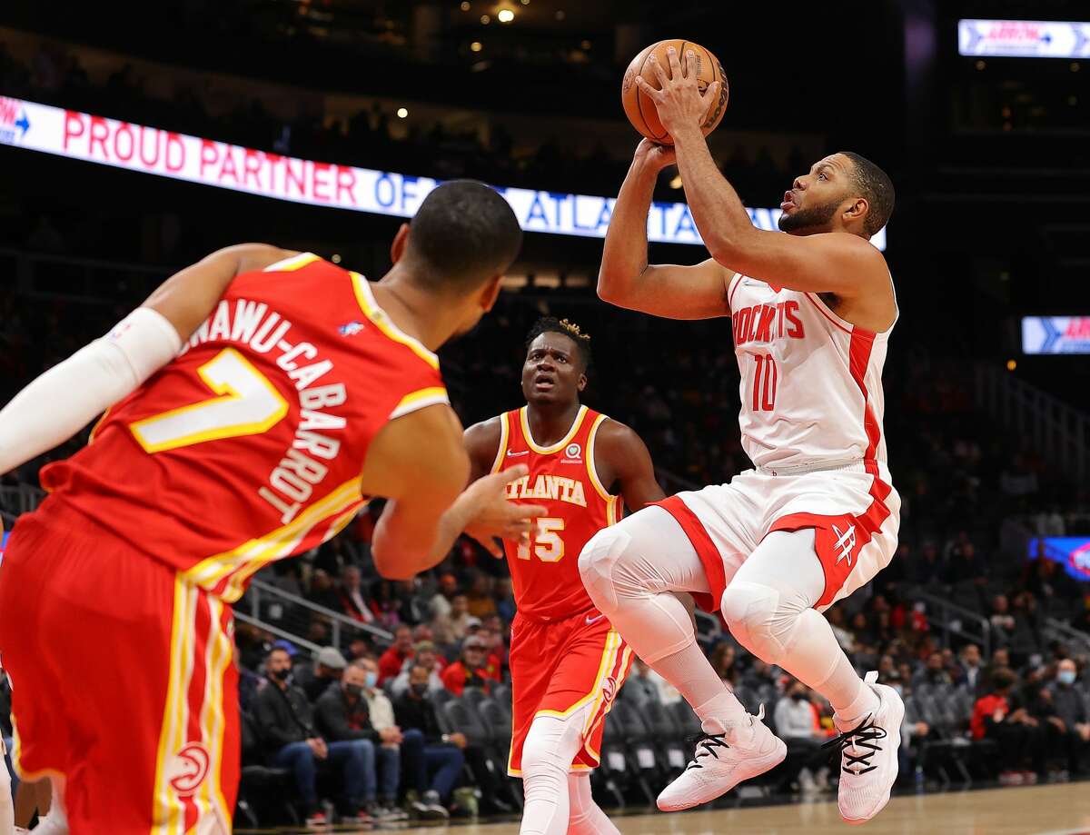 ATLANTA, GEORGIA - DECEMBER 13: Eric Gordon #10 of the Houston Rockets attempts a shot against Timothe Luwawu-Cabarrot #7 and Clint Capela #15 of the Atlanta Hawks during the first half at State Farm Arena on December 13, 2021 in Atlanta, Georgia. NOTE TO USER: User expressly acknowledges and agrees that, by downloading and or using this photograph, User is consenting to the terms and conditions of the Getty Images License Agreement. (Photo by Kevin C. Cox/Getty Images)