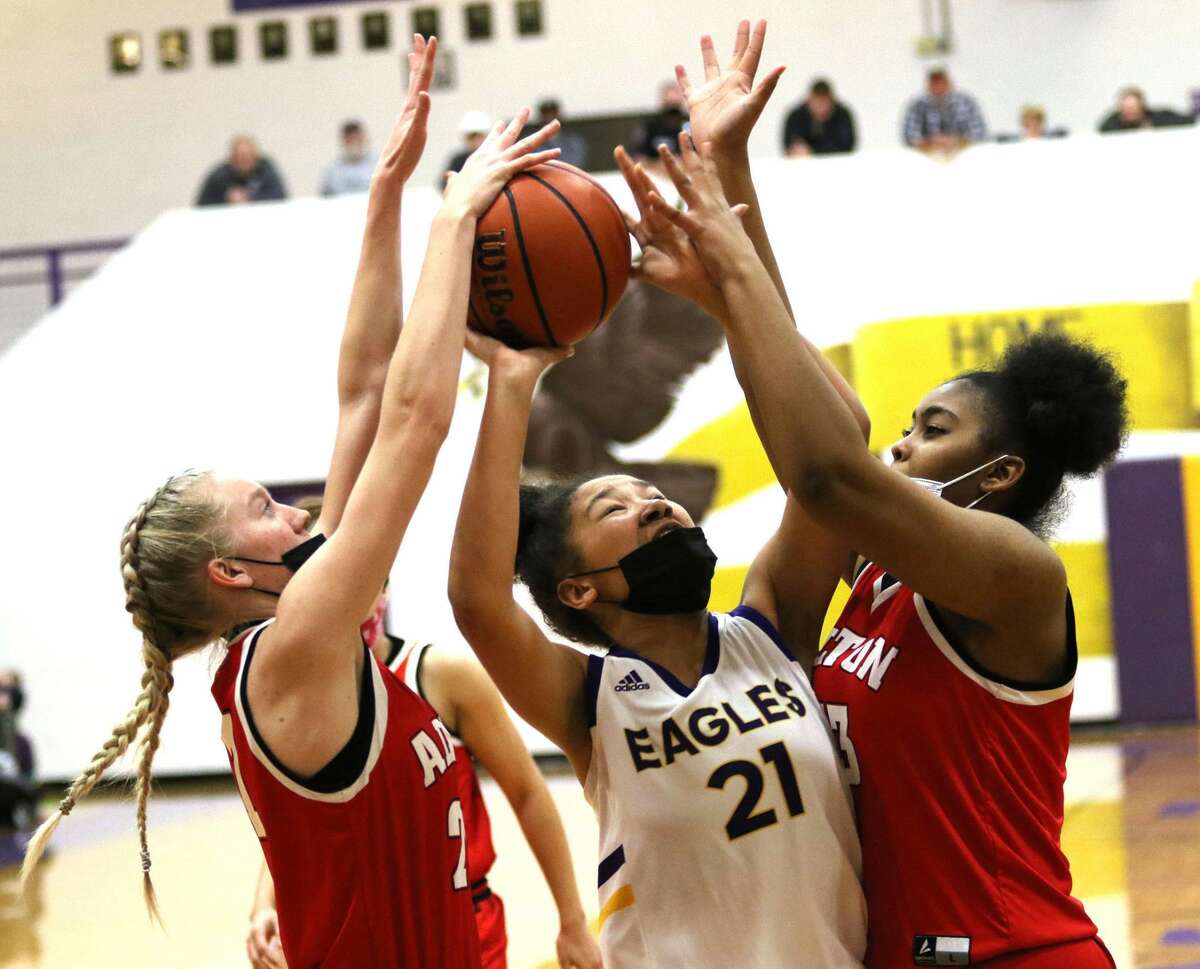 CM's Maya Tuckson (21) tries to get off a shot between Alton's Tayen Orr (left) and Talia Norman on Monday night in Bethalto.