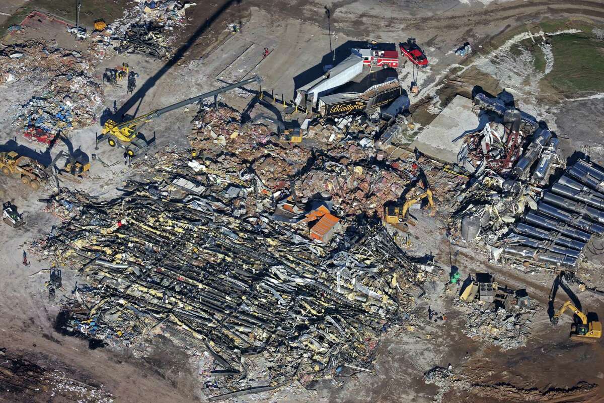 In this aerial view, crews clear the rubble at the Mayfield Consumer Products candle factory after it was destroyed by a tornado three days prior, on December 13, 2021 in Mayfield, Kentucky.