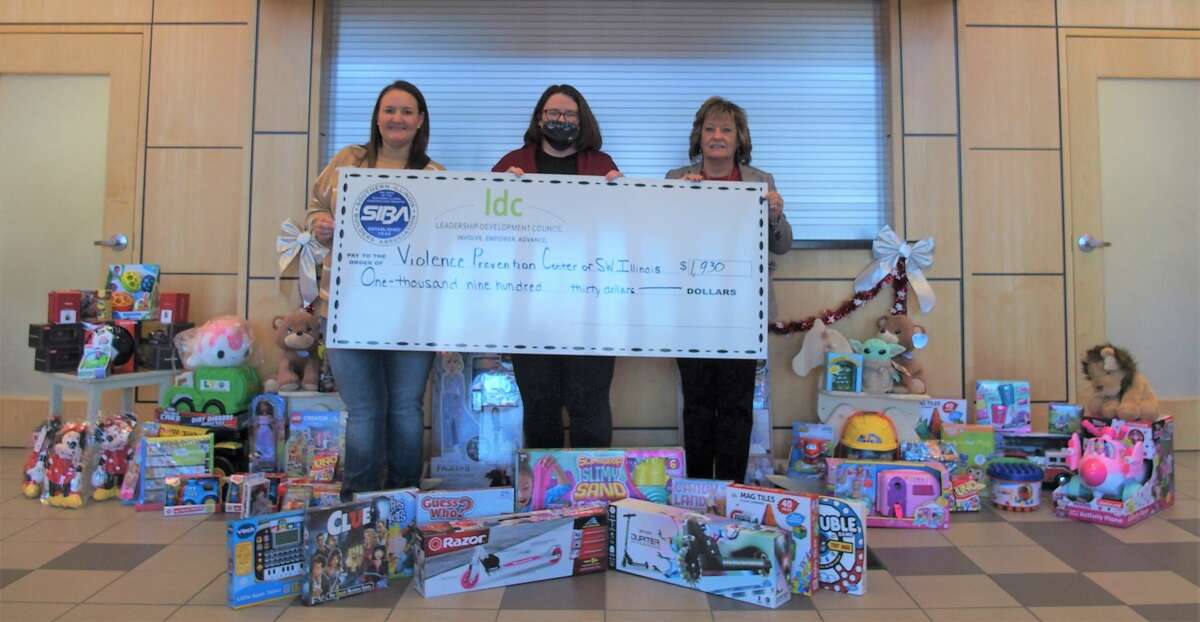 Stacy Friederich (left), Chair of the SIBA Leadership Development Council; and Donna Richter (right), CEO, Southern Illinois Builders Association; present toys and cash donation to Melissa Tutterow (center), Director of Development, Violence Prevention Center of Southwestern Illinois.