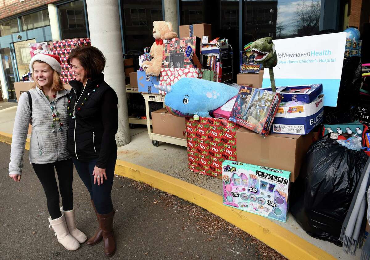 Faith Tremblay (far left) of Madison and her mother, Lisa, are photographed in front of some of the 5,000 toys collected in the 4th Faith's Annual Toy Drive that were unloaded at Yale New Haven Hospital last year.
