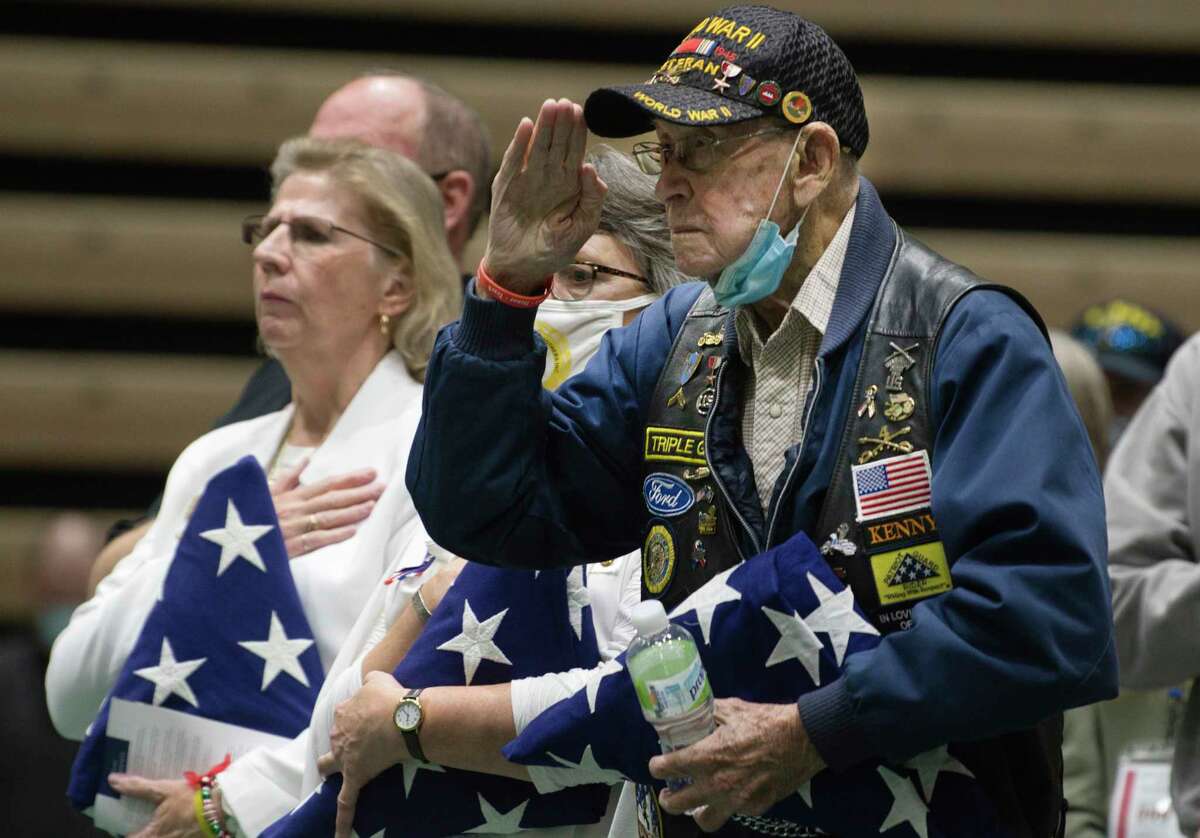 World War II Army veteran Ken Bailey, right, salutes as he stands with Gold Star Mothers, Cindy Roberts, left, and Carrie Farley, center, during an event for Wreaths Across America at Hudson Valley Community College on Tuesday, Dec. 14, 2021, in Troy, N.Y. All three were presented with folded flags during the event. Wreaths Across America organization collects sponsored veterans?• wreaths to lay at Arlington National Cemetery, and more than 3,100 additional participating locations across the country each December. The organization was started with mission to remember those who died during service, to honor those serving and to teach about the value of freedom. The caravan will arrive at Arlington National Cemetery on Saturday, Dec. 18th.