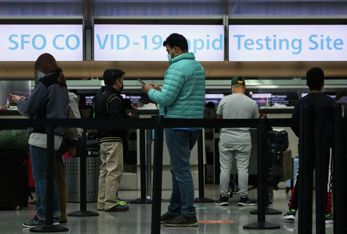 People line up at the SFO COVID-19 Rapid Testing Site at the San Francisco International Airport earlier this month. Testing has ramped up as the omicron variant arrives.