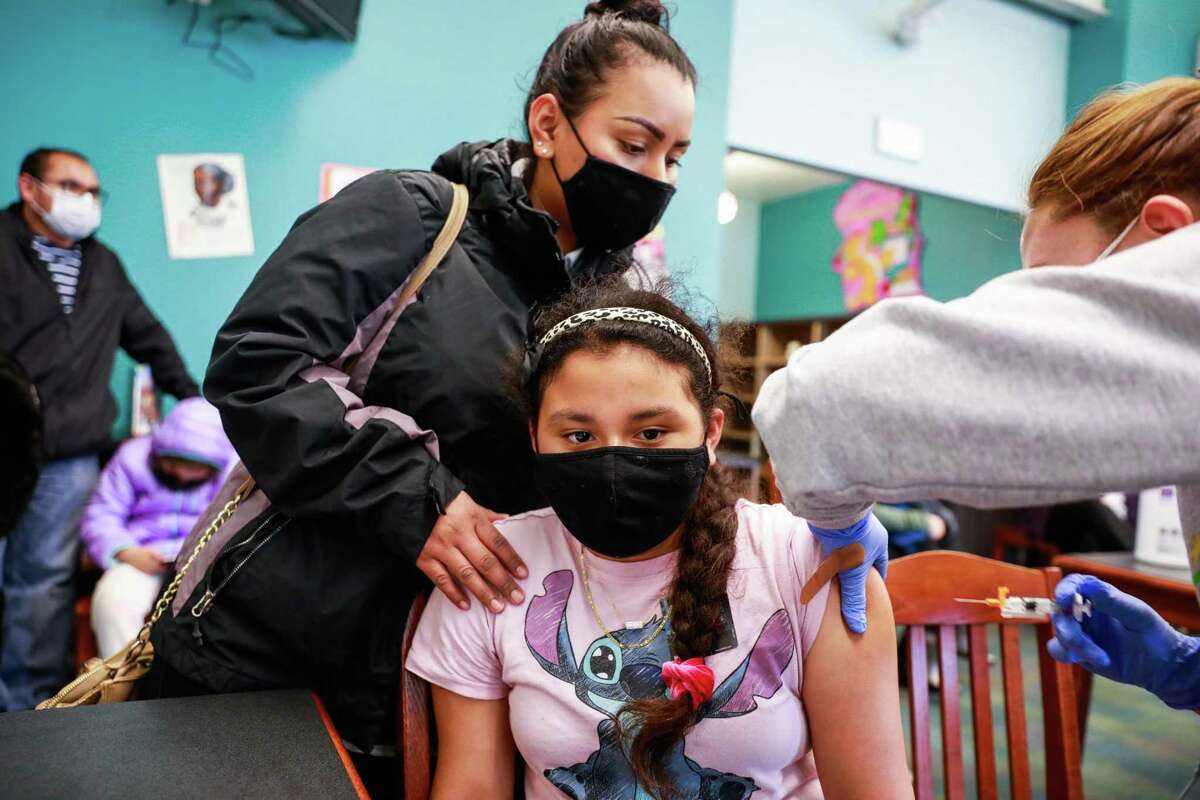 Mom Gabriela Martinez holds daughter Lisseth Gonzalez, 10, as she prepares to get her COVID-19 vaccine on in Richmond, Calif.