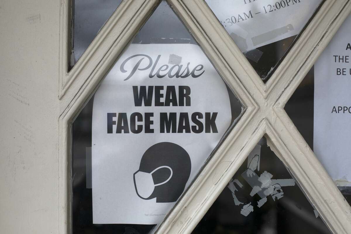 A sign reminds patients to wear a mask at a medical office in Oakland, Calif.