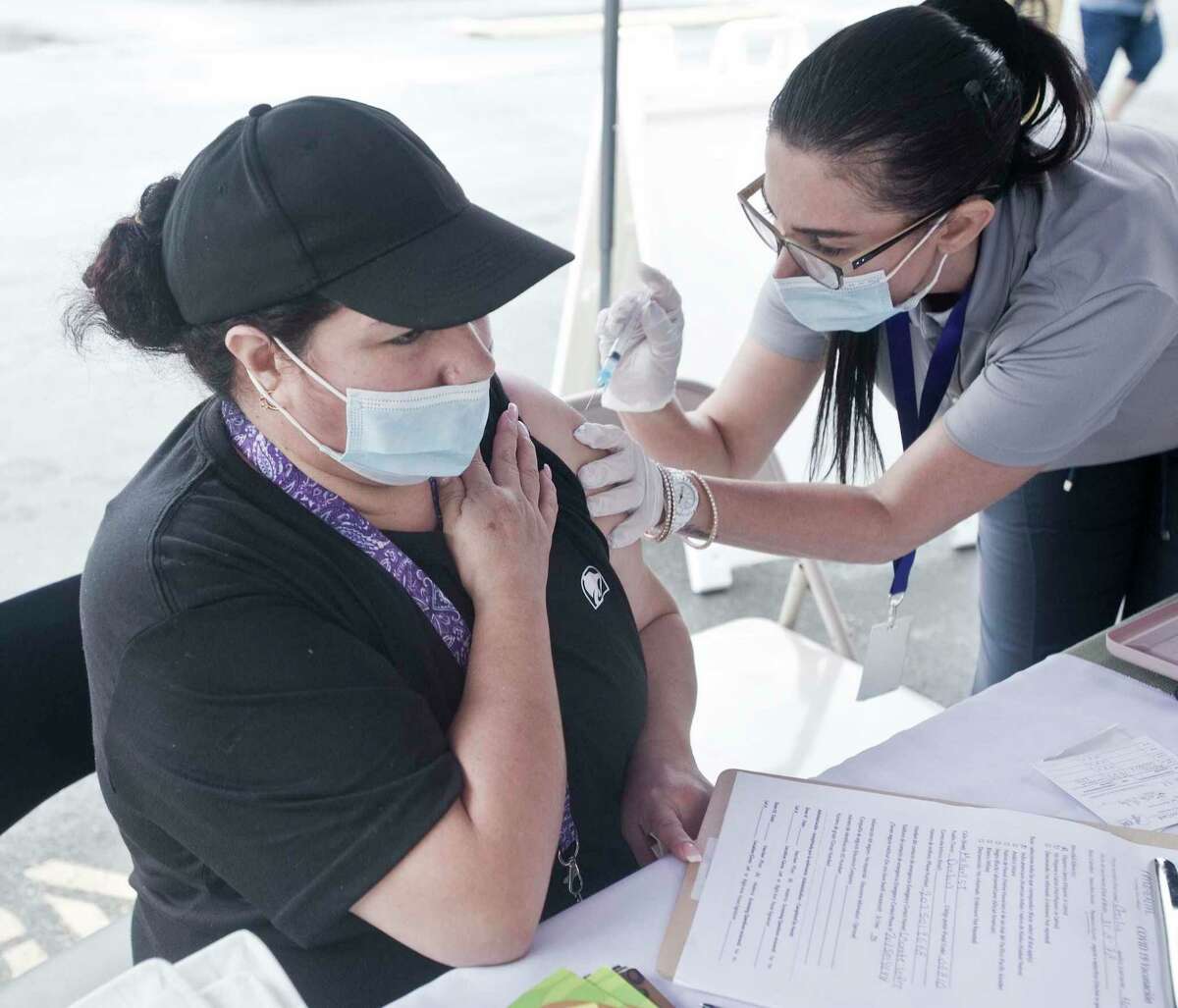 Cecilia Meza, of Danbury, receives a COVID-19 vaccination from Fernanda Araujo, a nurse with the Ridgefield Visiting Nurse Association, at CTown Supermarket in Danbury in June.