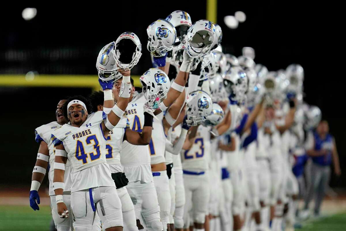 Serra players hold up their helmets as the national anthem plays before the 2021 CIF Open Division high school football state championship game against Mater Dei Saturday, Dec. 11, 2021, in Mission Viejo Calif. (AP Photo/Ashley Landis )