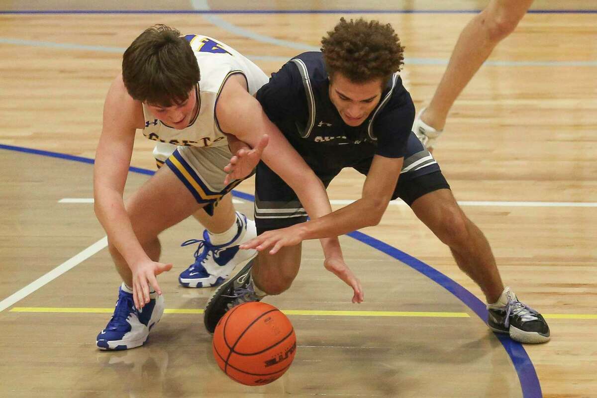 Alamo Heights’ Gage Wright (40) and Boerne-Champion’s Jesse Peart (4) fight for a loose ball during the second quarter at Alamo Heights High School in San Antonio, Texas, Tuesday, Dec. 14, 2021. The Chargers defeated the Mules 62-42.