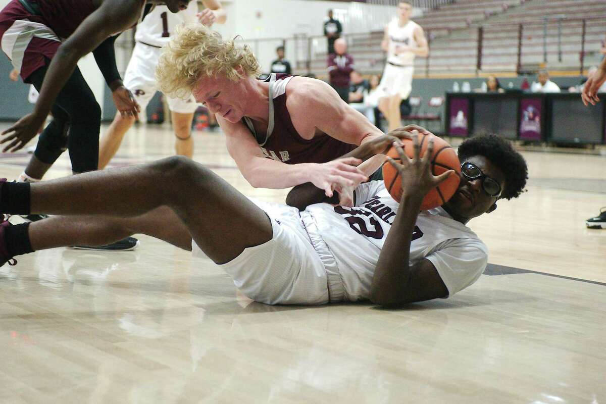 Pearland’s Ezenna Ibe (32) and Clear Creek’s Austin Lenz (42) fight for a loose ball Tuesday at Pearland High School.