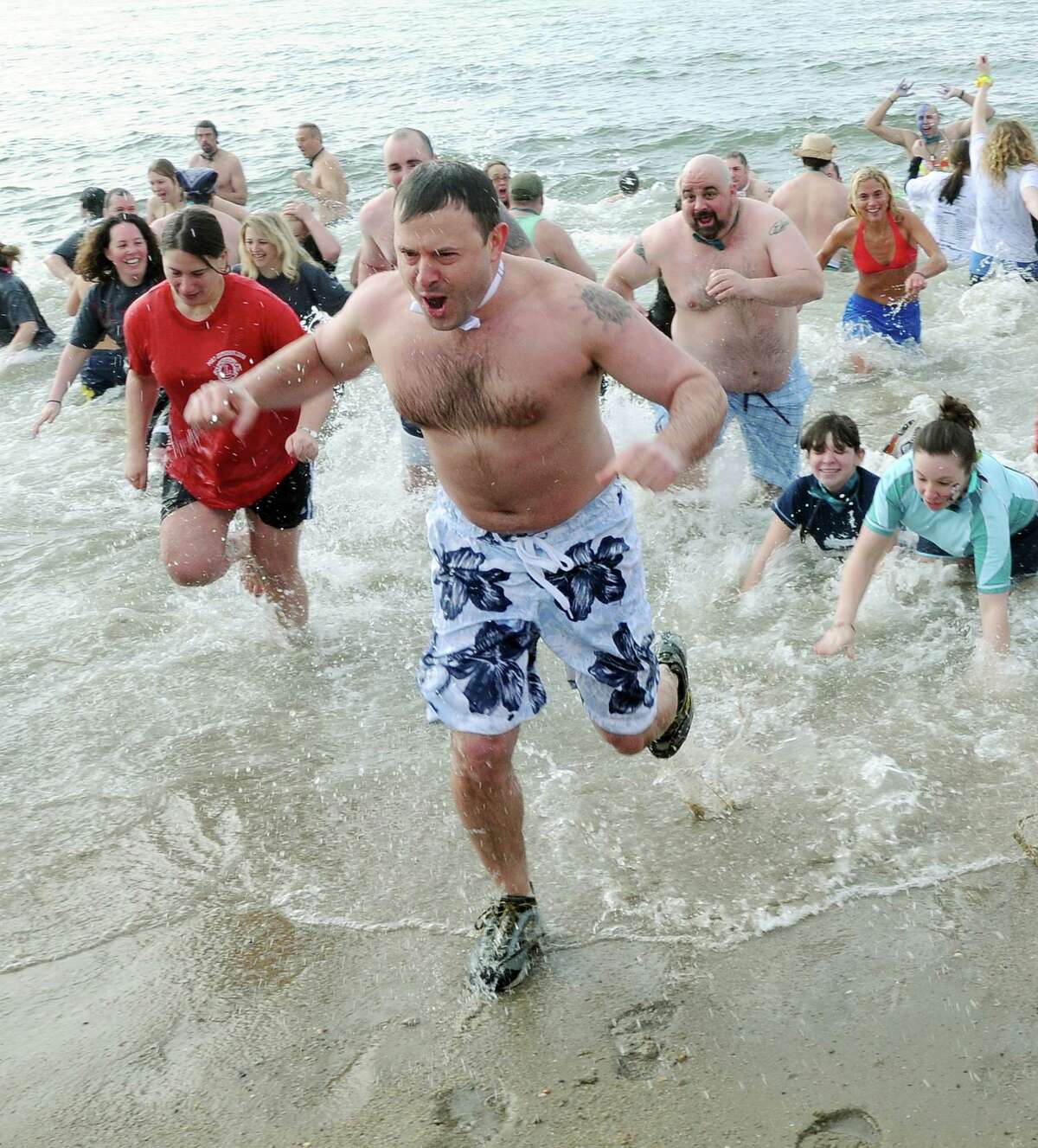Runners emerge from the water in the 20th Madison Penguin Plunge.