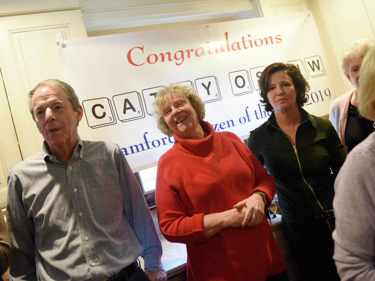Cathy Ostuw, co-founder of Building One Community, is surprised in a friend's home in Stamford, Conn. to learn that she is this year's Stamford Citizen of the Year winner on Thursday, Dec. 12, 2019. Ostuw was heading to her weekly Scrabble game with friends when Mayor David Martin and dozens of friends and colleagues suprised her with the honor, which is sponsored by Post 142 of the Jewish War Veterans of the United States. Building One Community's mission is to advance the successful integration of immigrants and their families.
