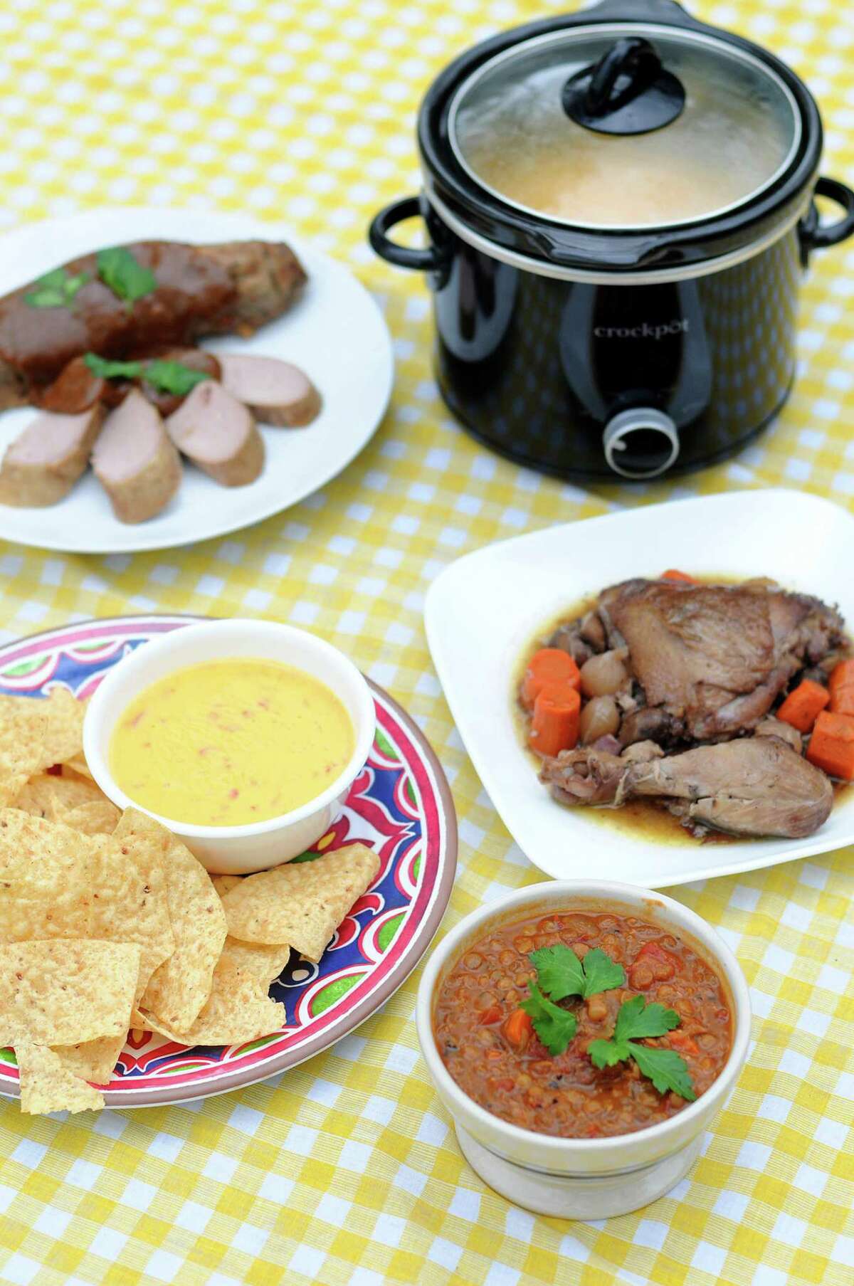 A selection of dishes made in a slow cooker including (clockwise from top left) Slow Cooker Honey Mustard Pork Tenderloin, Slow Cooker Coq Au Vin, Vegan Slow Cooker Lentil Soup and Classic Slow Cooker Queso