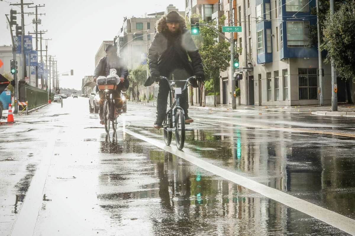 People bike through the rain in San Francisco, Calif. After a brief respite from the rain, more preciptitation — including snow in some higher elevations — was expected across the Bay Area.