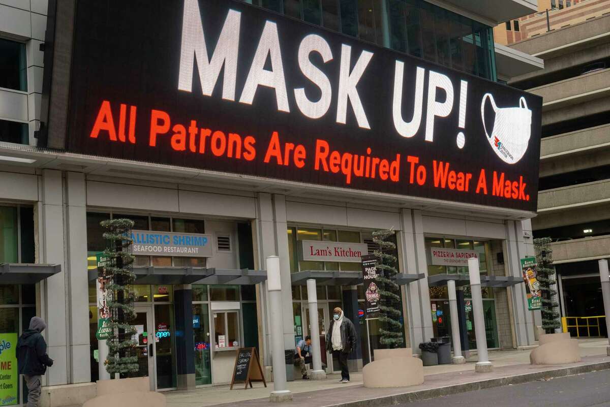 A screen above restaurants at the Times Union Center reminds patrons that wearing a mask is required in all businesses on Wednesday, Dec. 15, 2021 in Albany, N.Y. Businesses are posting signs on their doors requiring customers to wear face mask due to a state government mandate.