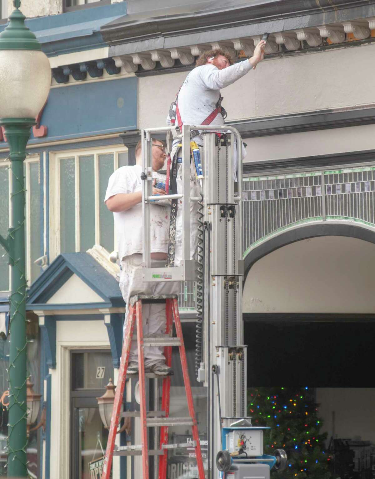 Robert Kress (left) and Nick Cosgriff of J.B. Large & Sons touch up and paint trim above the entrance to the Edward Jones office at 25 S. Central Park Plaza in downtown Jacksonville on Wednesday.