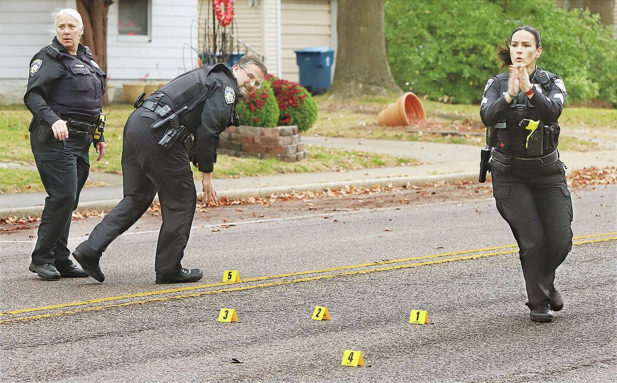 John Badman|The Telegraph Alton officers scramble Wednesday to stop a car that was accidently driving into their crime scene in the 1600 block of Main Street where officers were working to document and recover five shell casings from the street. Shots were reportedly at about 11:10 a.m. Wednesday. The suspect vehicle was gone when officers arrived and no injuries were reported. The incident remains under investigation.