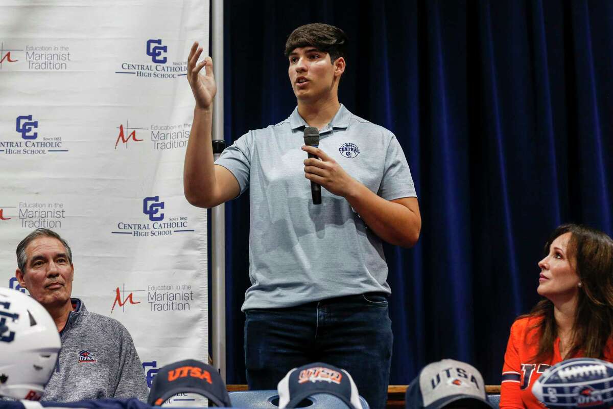 Ben Rios, center, speaks to the crowd as he stands next to his parents Raul, left, and Irene Rios, right, during the National Signing Day ceremony held inside the old historic gymnasium at Central Catholic High School in San Antonio, Texas, Wednesday, Dec. 15, 2021. Rios will join the UTSA football team next year.