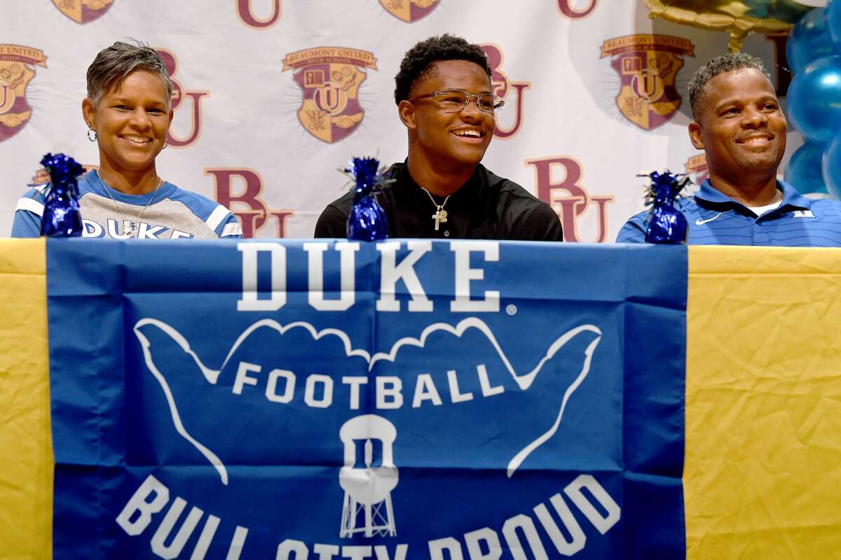 Beaumont United's Chandler Rivers gathers on stage with family, including parents Cheryl and Derrrick, as he signs with Duke University during an early signing day event at the school Wednesday. Photo made Wednesday, December 15, 2021 Kim Brent/The Enterprise