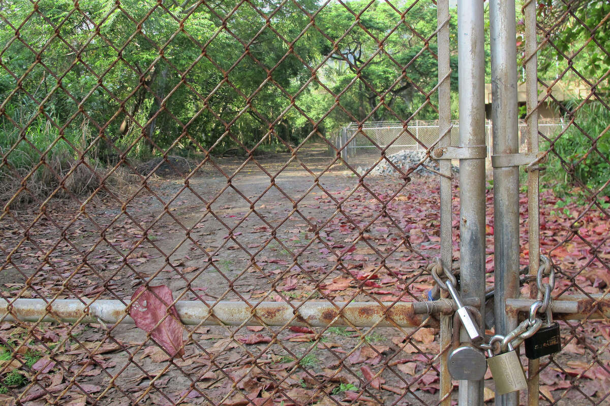 A gate is locked at the entrance to the now-closed Sacred Falls State Park in Hauula, Hawaii, on Wednesday, Feb. 18, 2015. Hawaii officials are turning to social media to counter online photos and statements encouraging people to visit the waterfall, where a landslide killed eight people more than 15 years ago.