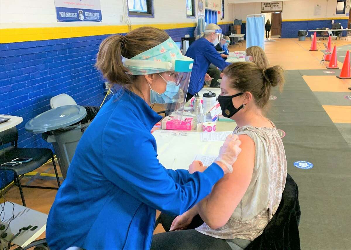 Registered nurse Jenna Haley, manager of Charlotte Hungerford Hospital’s Cardio and Pulmonary Rehab unit, prepares Thomaston High School teacher Erica Flanagan for her first vaccination at a Torrington clinic for local educators in March.